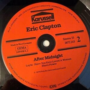 Używane winyle, Płyty winylowe na sprzedaż, sklep winyle online Zbliżenie na starą płytę z jaskrawo pomarańczową etykietą: „Eric Clapton – Blues Power EX”, z takimi klasykami jak „After Midnight”, „Layla” i innymi. Czarny winyl dodaje kontrastu. Znajdź podobne perełki w swoim ulubionym sklepie *płyty winylowe*, aby wzbogacić swoją kolekcję. Sklep online z winylami